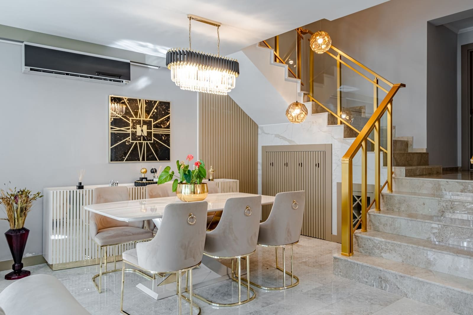 Dining room beside a staircase with pendant lights